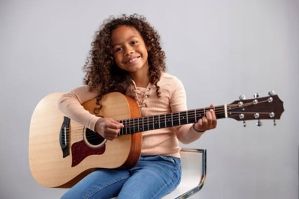 Niña en clases de guitarra para colegios