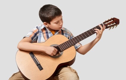 Niño en las extraescolares de guitarra