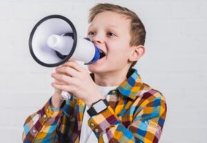 Niño con megáfono en extraescolares de oratoria