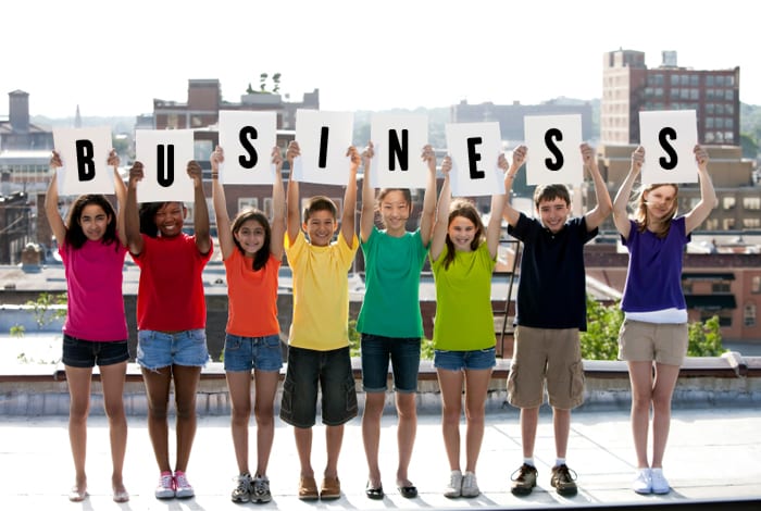 Grupo de niños con un cartel en las extraescolares de emprendimiento